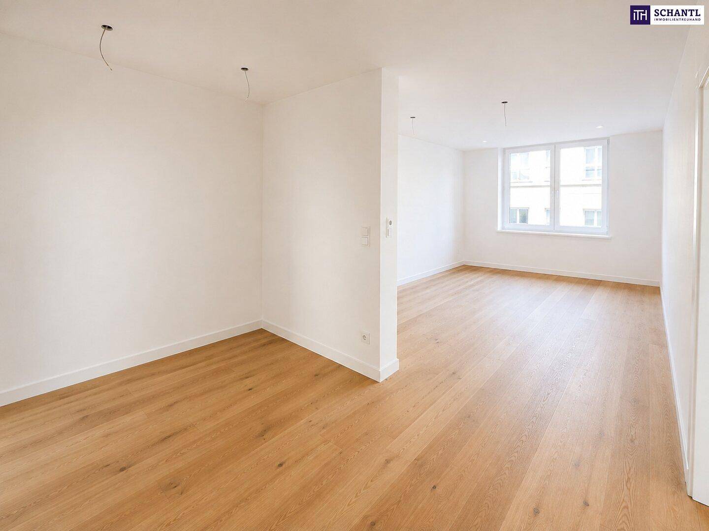 Heller, unmöblierter Wohnraum mit neuem Holzparkettboden und großen Fenstern, bereit zum Einzug.