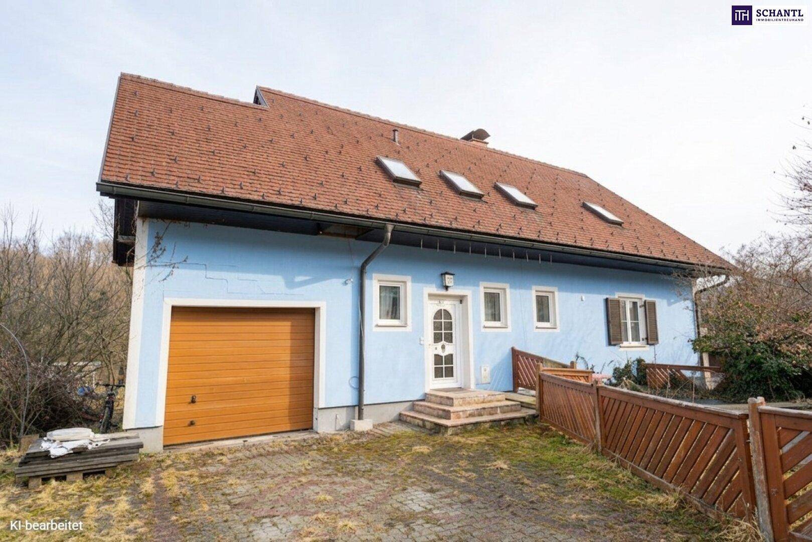 Vorderansicht des Hauses mit hellblauer Fassade, braunem Garagentor und Eingangsbereich.