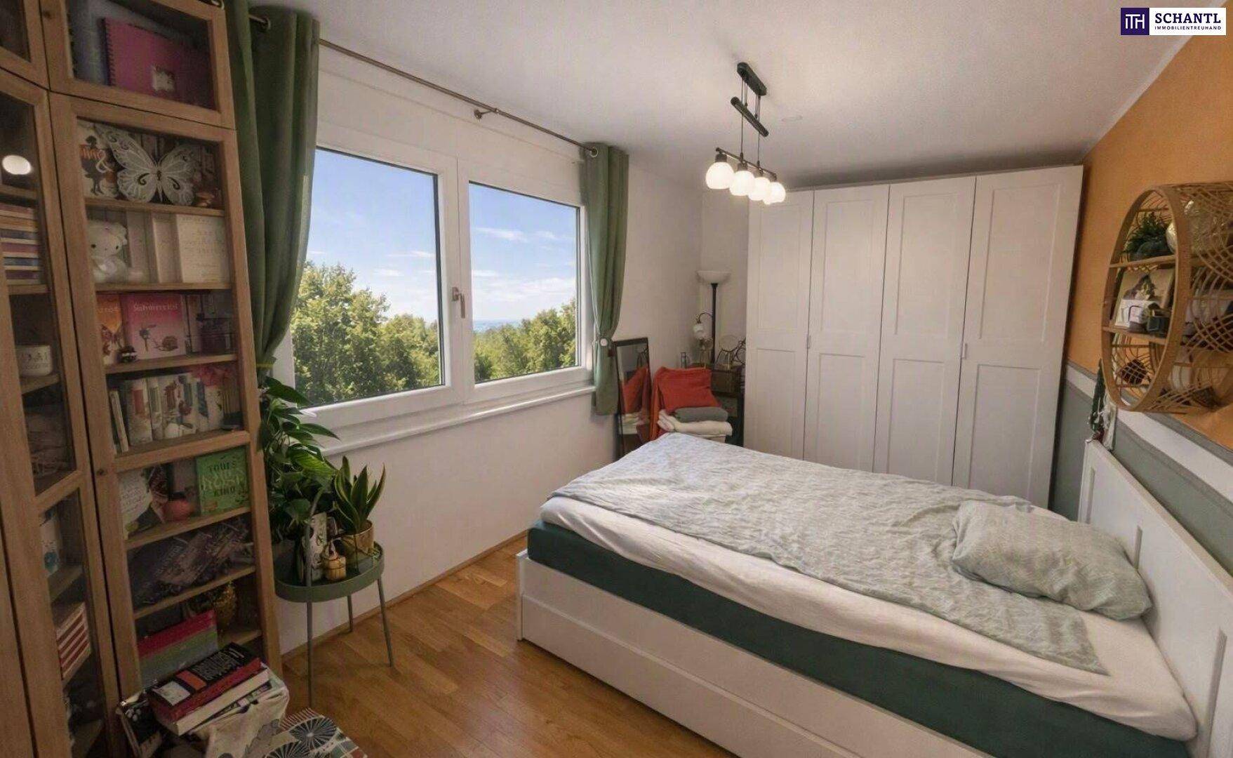 Gemütliches Schlafzimmer mit Holzboden, großem Fenster und Blick ins Grüne.
