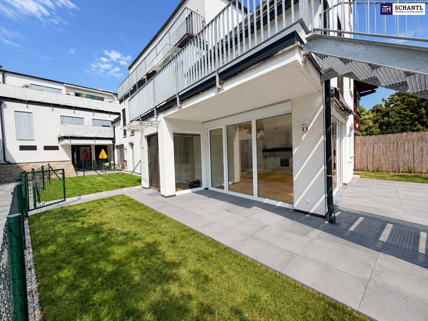 Geräumige Terrasse mit Fliesenboden und Zugang zum Gartenbereich des Hauses.