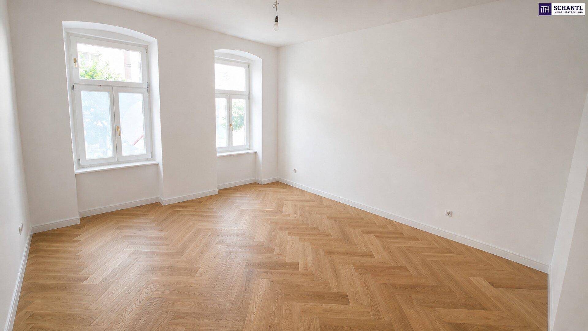 Helles, leeres Zimmer mit Fischgrätparkett und hohen Fenstern, bereit zur individuellen Gestaltung.