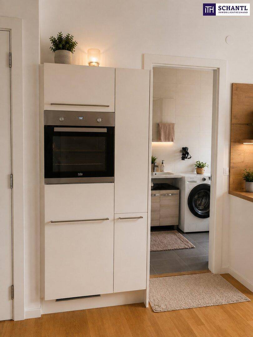 Praktischer Einbauschrank mit integriertem Backofen und Zugang zum Badezimmer mit Waschmaschine.