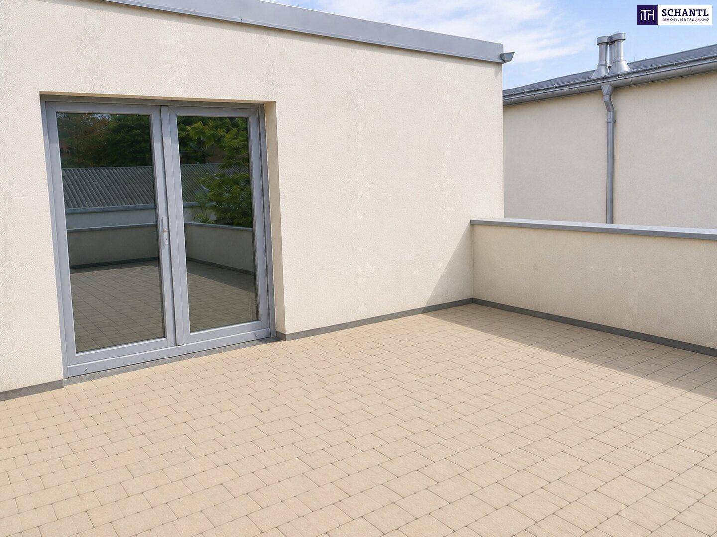Geräumige Dachterrasse mit hellem Pflasterboden und Zugang durch eine große Schiebetür.