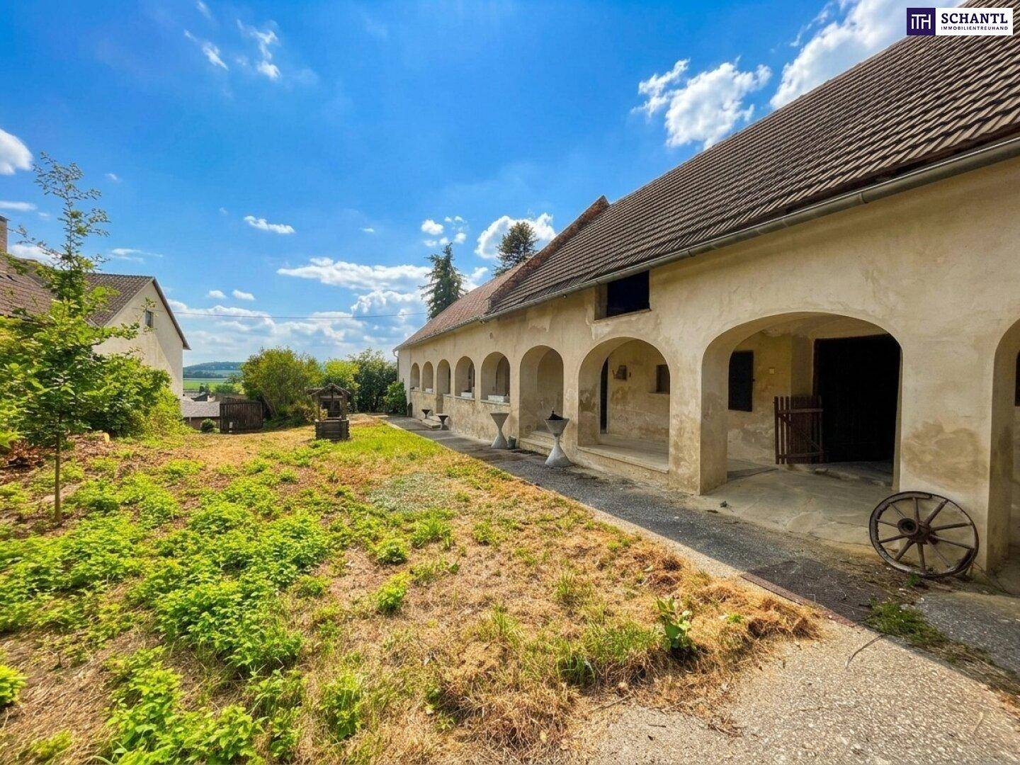 Weitläufiger Innenhof mit Arkadengang und Blick auf die umliegende Landschaft.