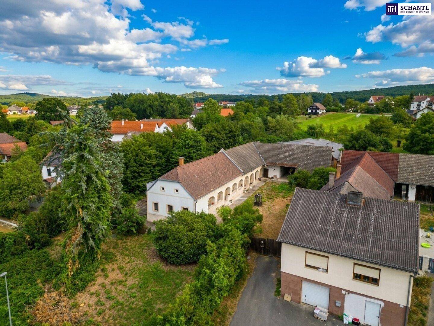 Luftaufnahme des Anwesens mit angrenzenden Häusern und der weiten Landschaft im Hintergrund.