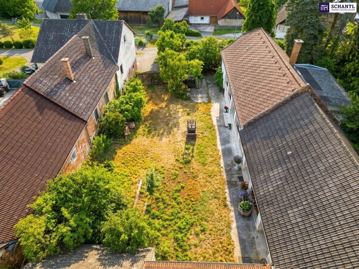 Vogelperspektive des Innenhofs mit dem Brunnen und den umliegenden Gebäuden.