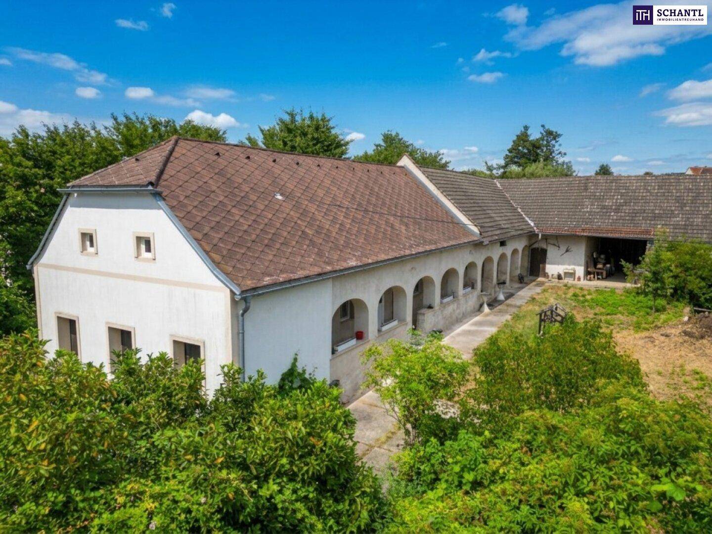 Luftaufnahme des Anwesens mit mehreren Gebäuden und einem großen, ungenutzten Innenhof.