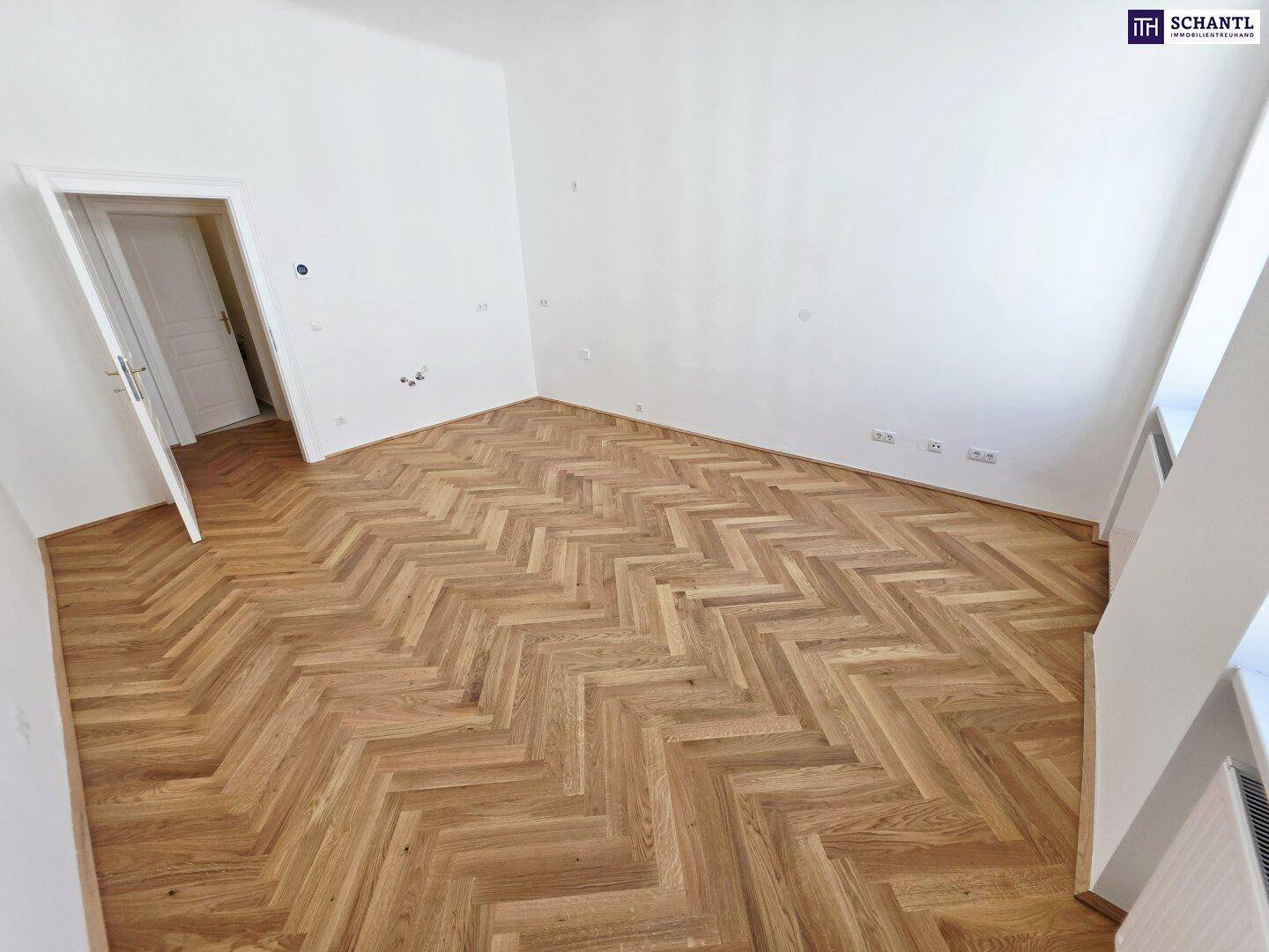 Leeres Zimmer mit neu verlegtem Fischgrätparkett und weißer Wandfarbe, bietet viel Gestaltungspotenzial.