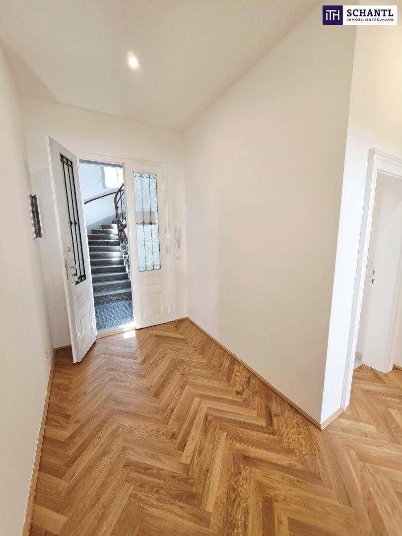 Heller Eingangsbereich mit Fischgrätparkett und Zugang zum Treppenhaus, einladend und geräumig.