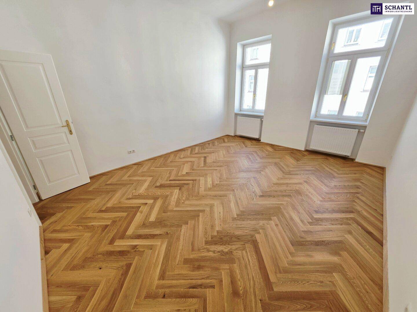 Helles und geräumiges Zimmer mit klassischem Fischgrätparkett und hohen Decken, ideal für Wohnzwecke.