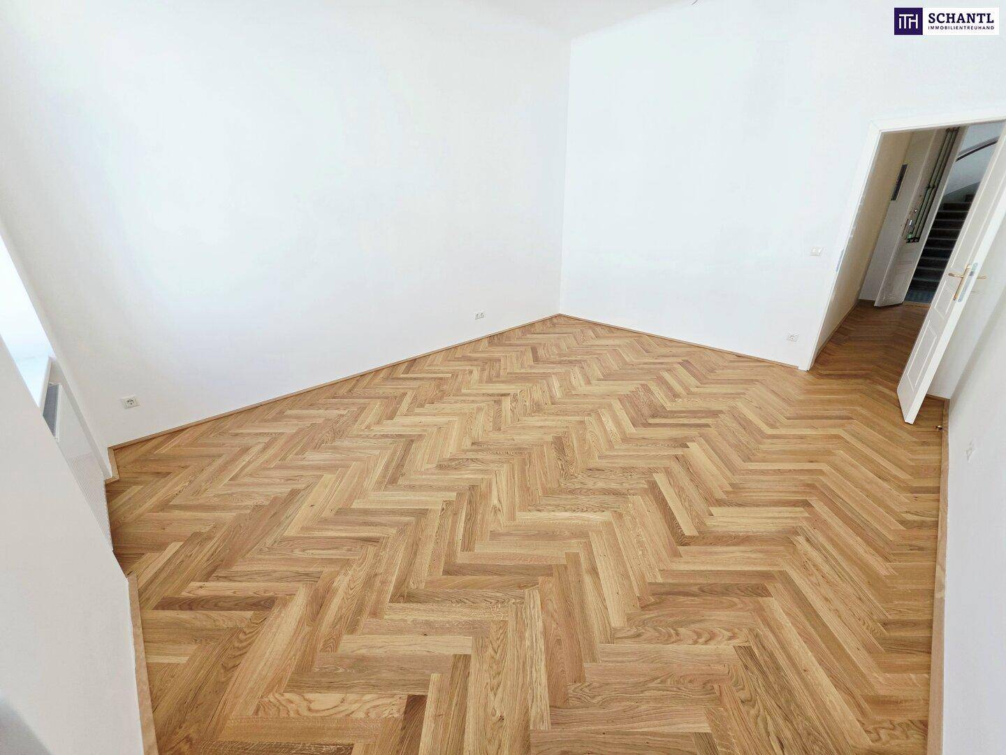 Renoviertes Zimmer mit neuem Fischgrätparkett und weiß gestrichenen Wänden, bietet eine helle Atmosphäre.