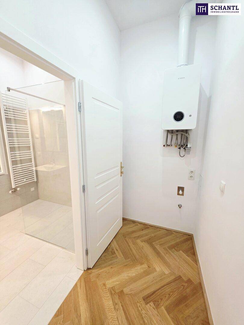 Hauswirtschaftsraum mit Gastherme und Zugang zum Badezimmer, mit Fischgrätparkett.