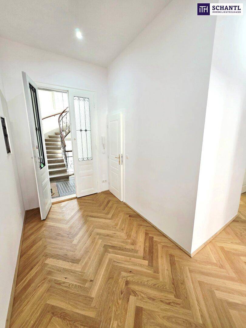 Eingangsbereich mit Fischgrätparkett und Blick auf das Treppenhaus, frisch renoviert.