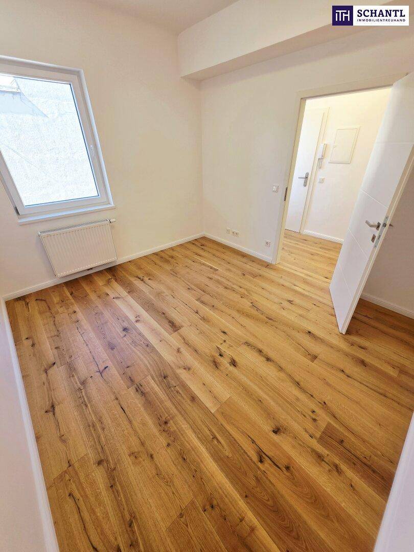 Gemütliches Zimmer mit Holzboden und schrägem Fenster, ideal als Schlaf- oder Arbeitszimmer.