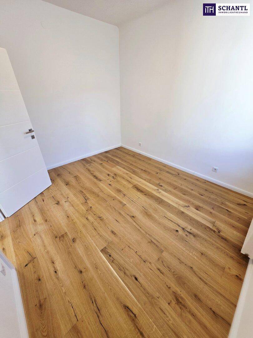 Kleines, helles Zimmer mit Holzboden und weißer Tür, vielseitig nutzbar.