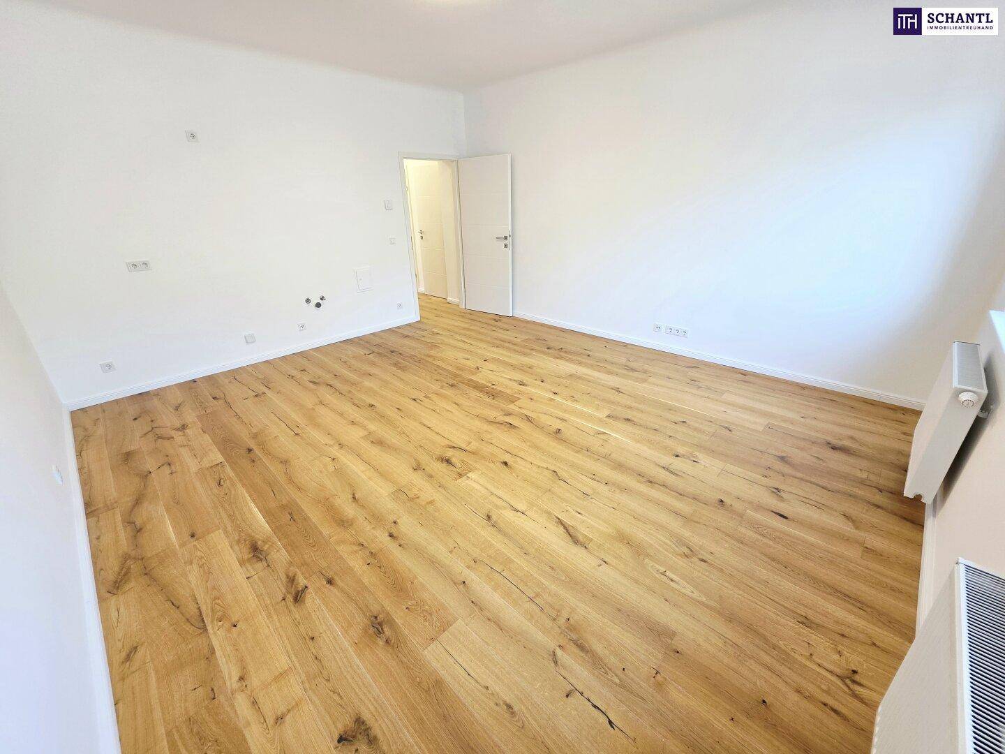 Leeres Zimmer mit neuem Holzboden und weißen Wänden, ideal für Schlaf- oder Arbeitsbereich.