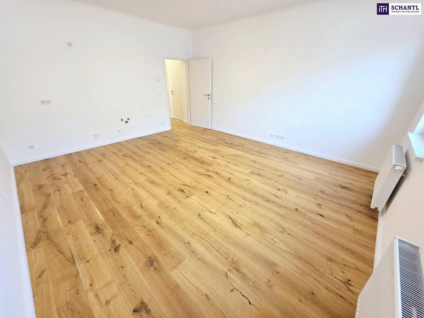Unmöbliertes Zimmer mit hellem Holzboden und weißen Wänden, bietet viel Potenzial für individuelle Einrichtung.