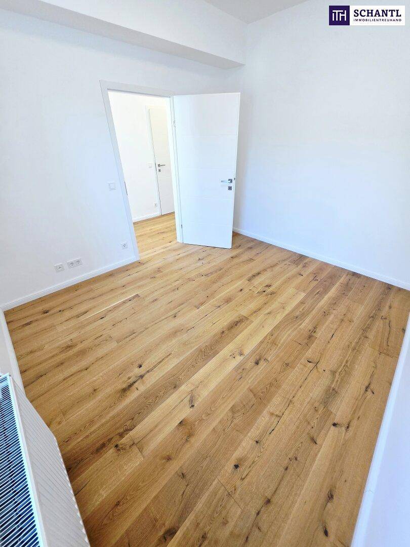 Helles Schlafzimmer mit Holzboden und Dachfenster, das viel natürliches Licht hereinlässt.