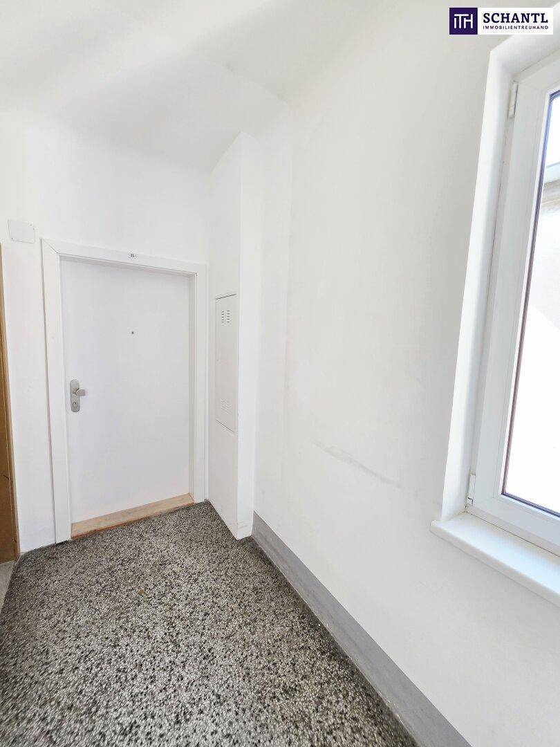 Eingangsbereich mit robustem Terrazzoboden und Fenster, das für Helligkeit sorgt.