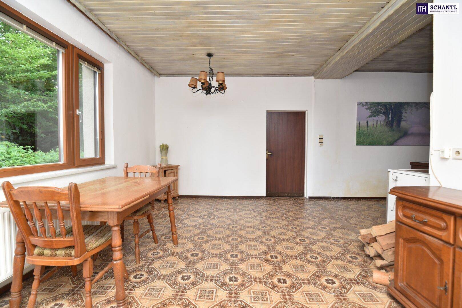 Essbereich in der rustikalen Küche mit Holztisch, Stühlen und Blick auf die Tür.