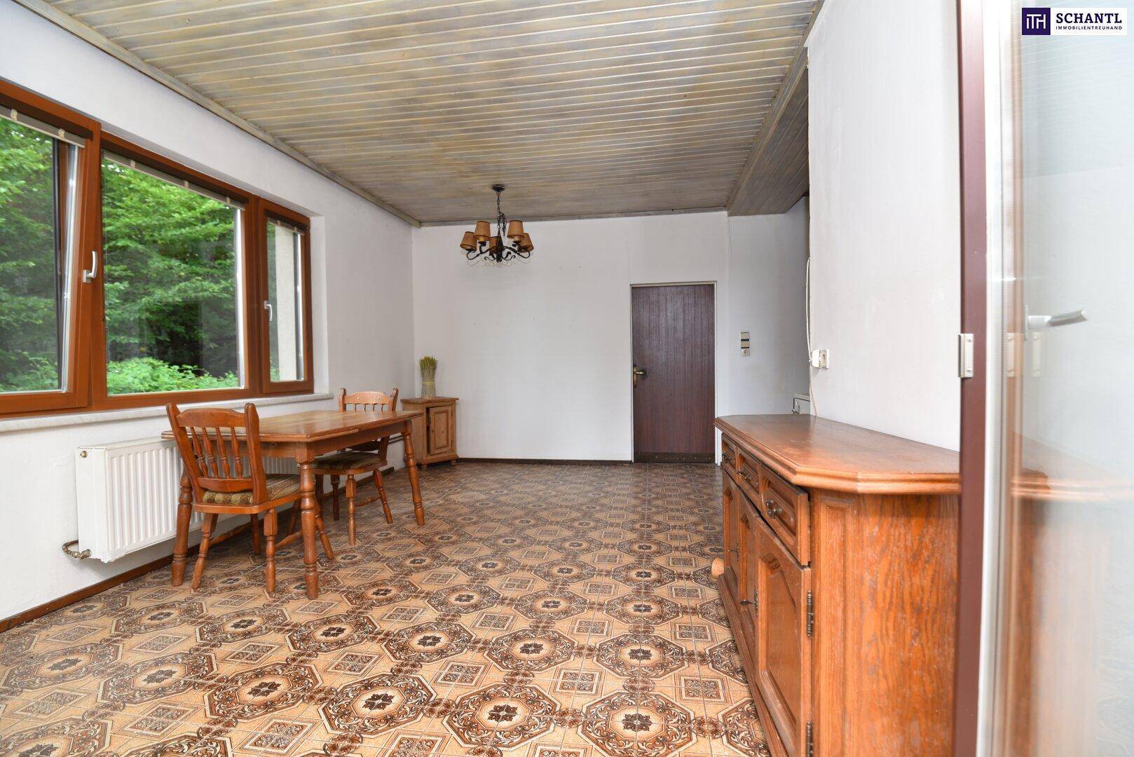 Rustikaler Essbereich mit Holztisch, Stühlen und einem traditionellen Sideboard in der Küche.