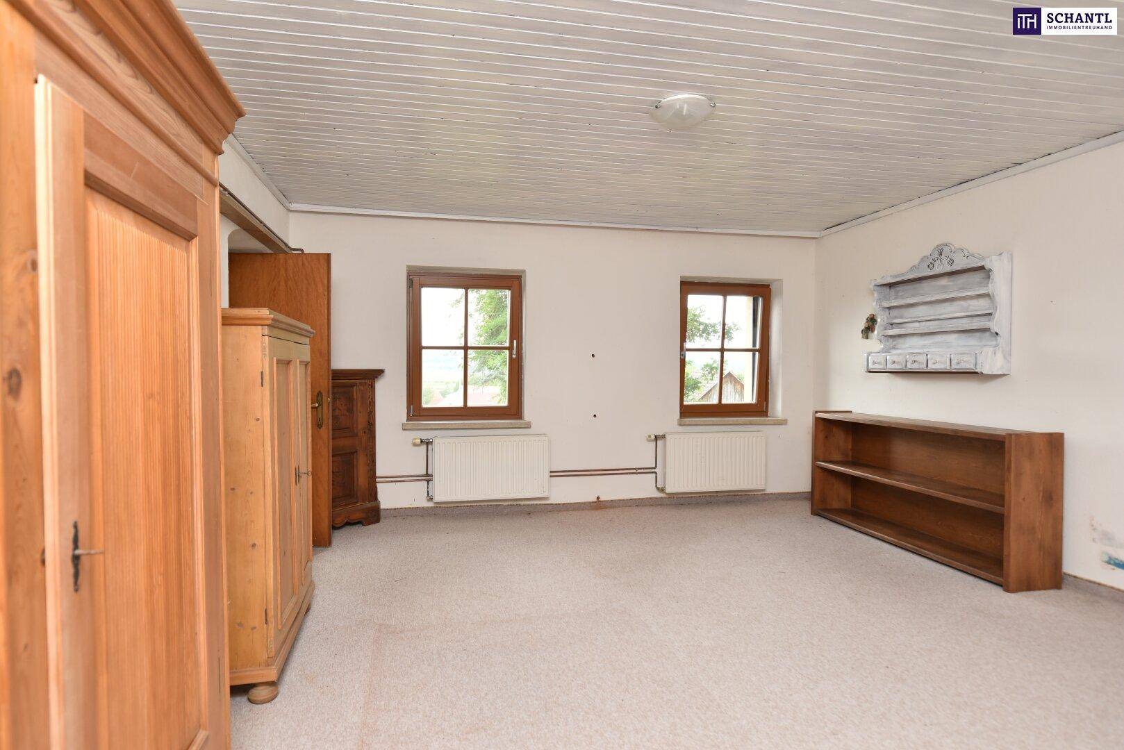 Geräumiges Schlafzimmer mit Teppichboden, zwei Fenstern und traditionellen Holzmöbeln.