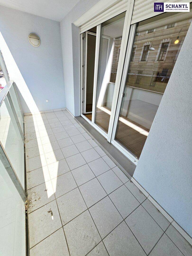Sonniger Balkon mit Fliesenboden und Blick auf die umliegenden Gebäude, ausgestattet mit Rollläden.