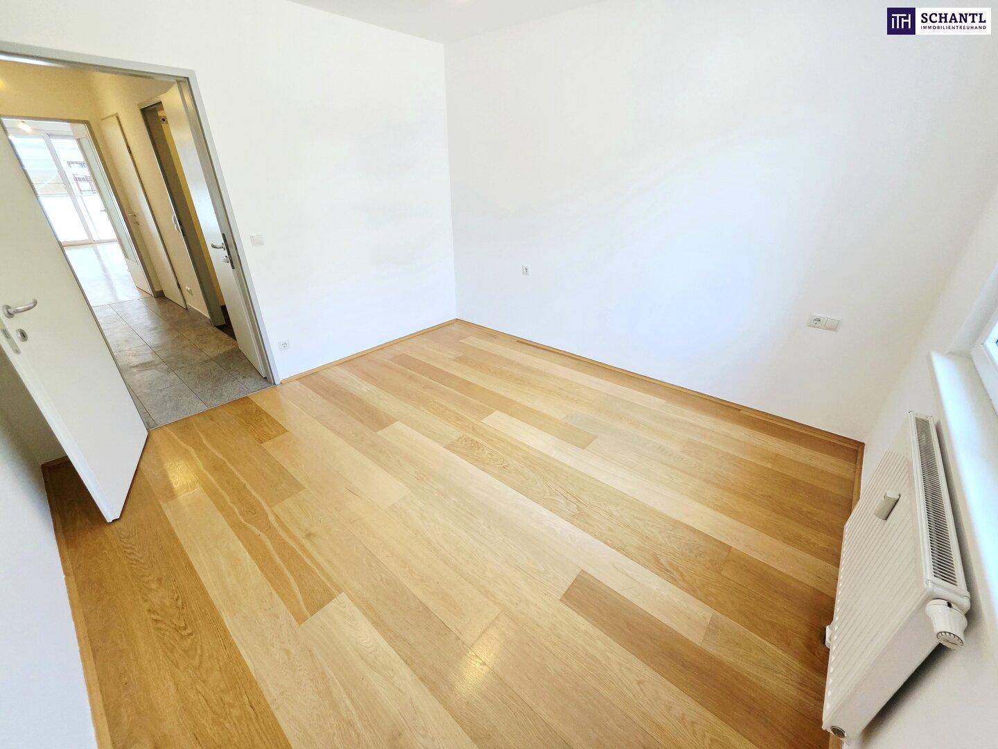 Geräumiges Schlafzimmer mit Holzboden und viel Tageslicht, ideal für Ruhe und Entspannung.