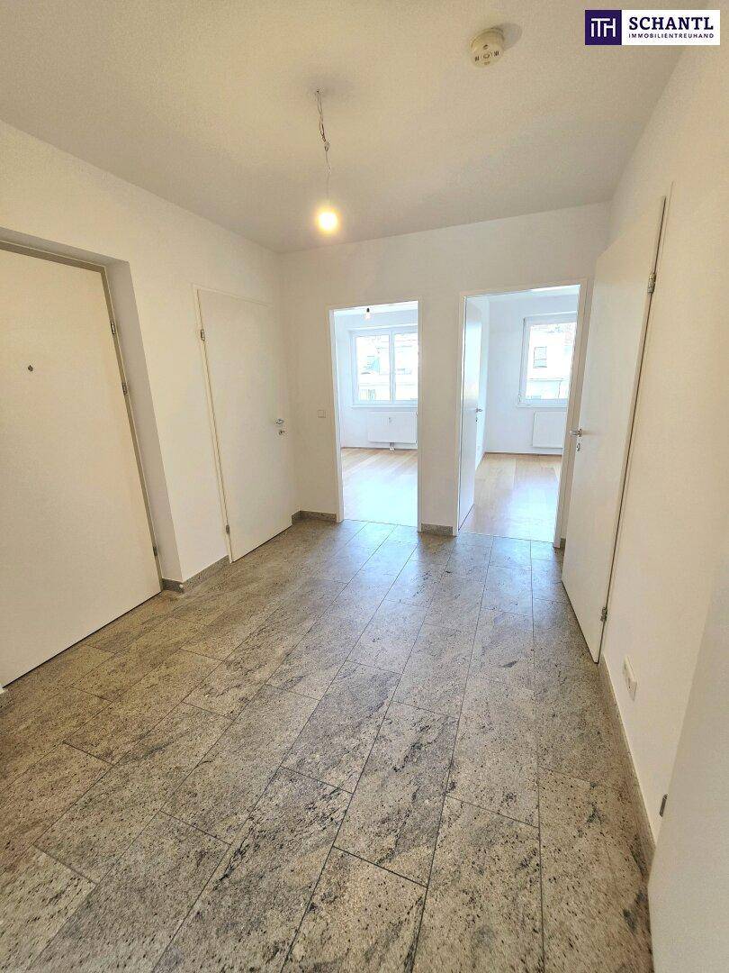 Heller Flur mit Fliesenboden und Zugang zu verschiedenen Zimmern der Wohnung.