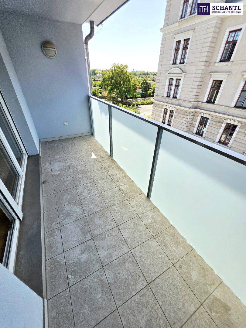 Moderner Balkon mit Glasbrüstung und Fliesenboden, bietet einen weiten Blick.