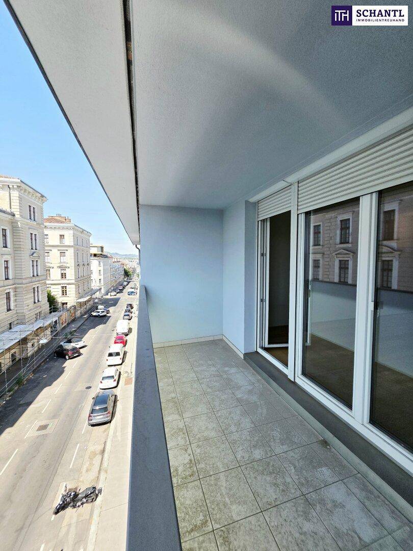 Langer Balkon mit Fliesenboden und Blick auf die belebte Stadtstraße.