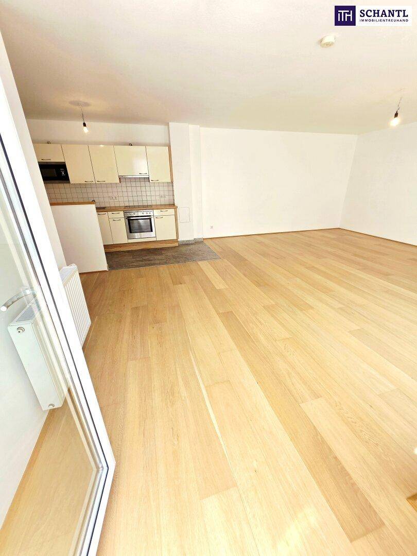Moderne Einbauküche mit hellen Schränken und Holz-Arbeitsplatte im offenen Wohnbereich.