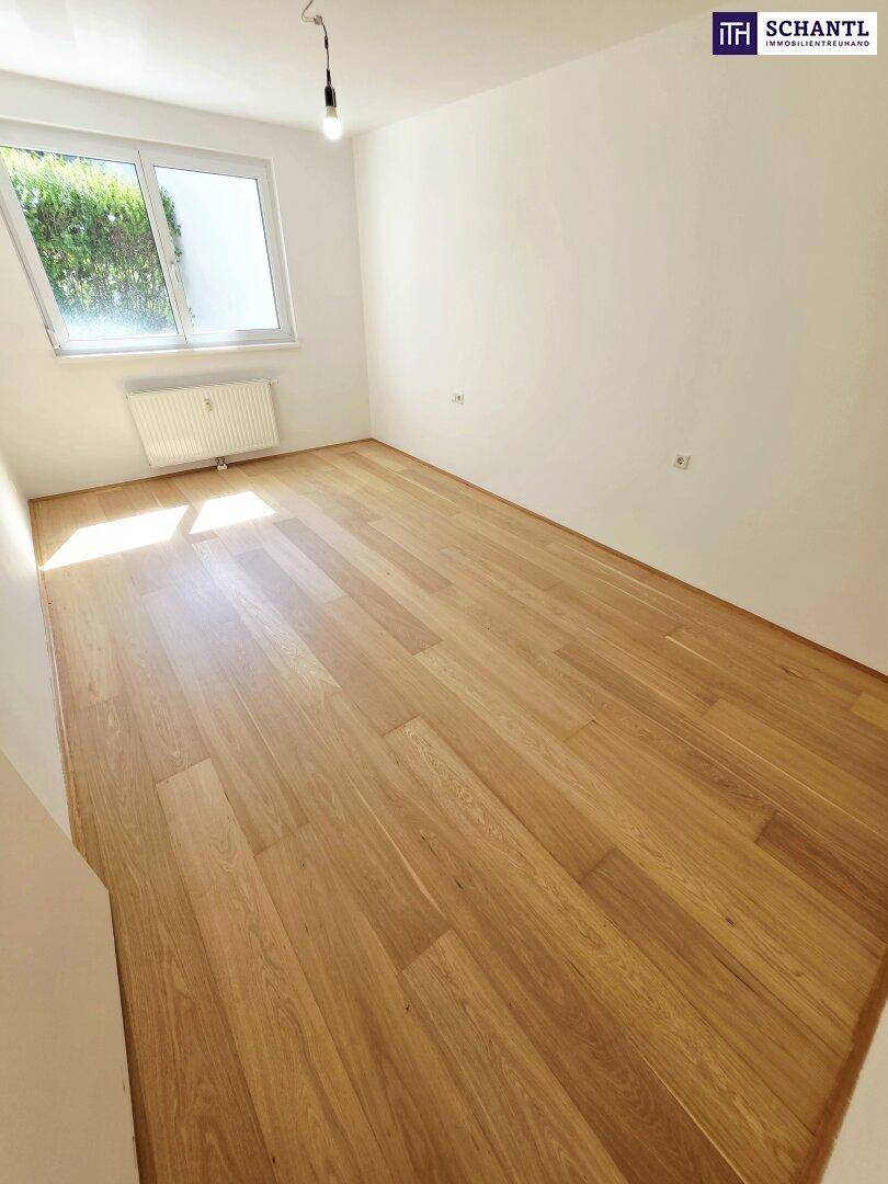 Geräumiges Schlafzimmer mit Holzboden und viel Tageslicht, bereit zur individuellen Einrichtung.