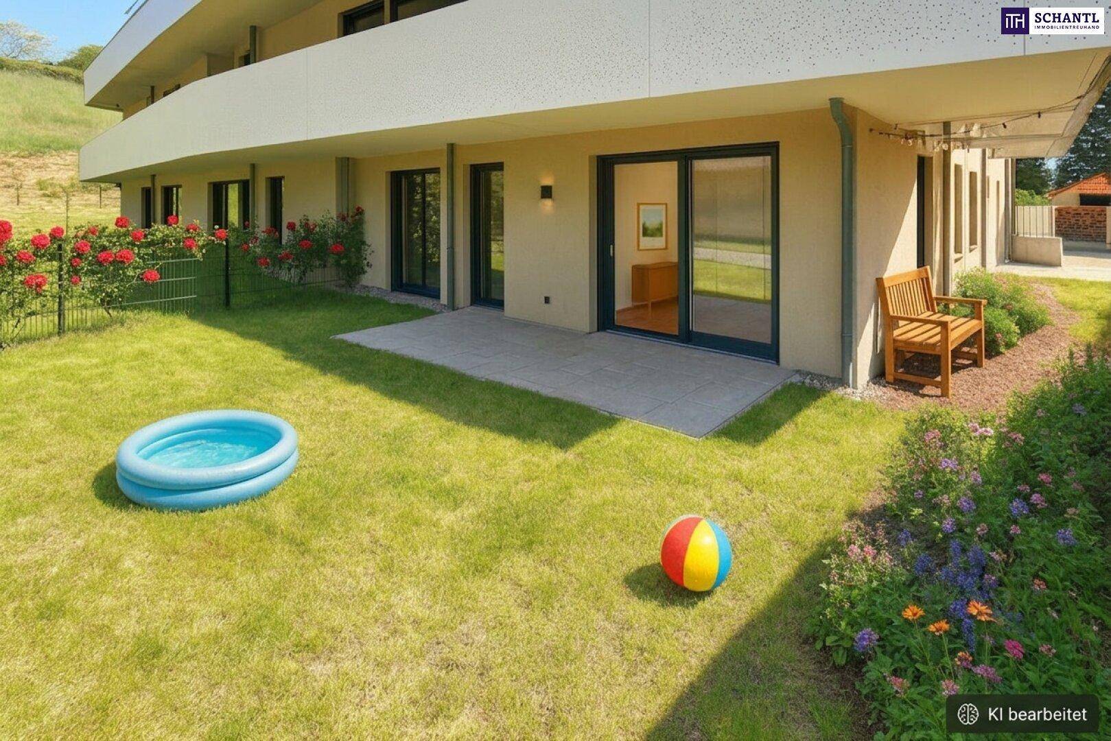 Gartenbereich mit kleiner Terrasse, Rasenfläche, Planschbecken und blühenden Rosen am Gebäude.