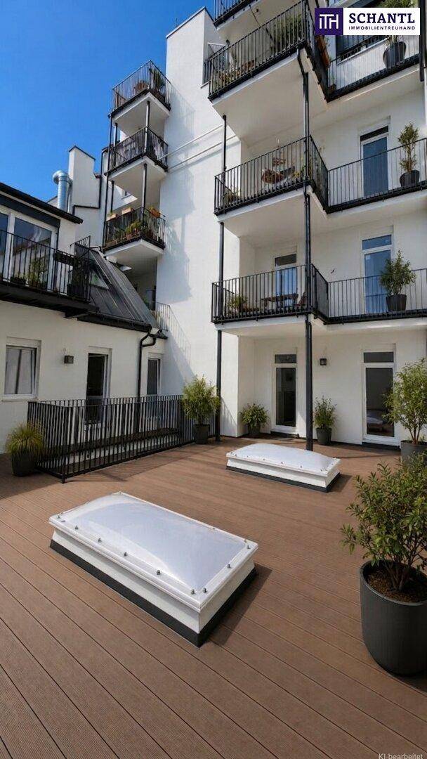 Moderne Wohnanlage mit weißer Fassade, zahlreichen Balkonen und einer großzügigen Holzterrasse mit Oberlichtern.