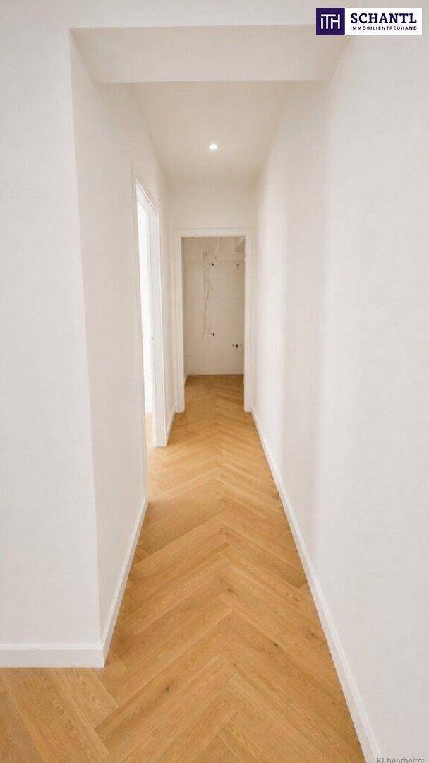 Heller Flur mit elegantem Fischgrätparkett, der zu weiteren Zimmern der Wohnung führt.