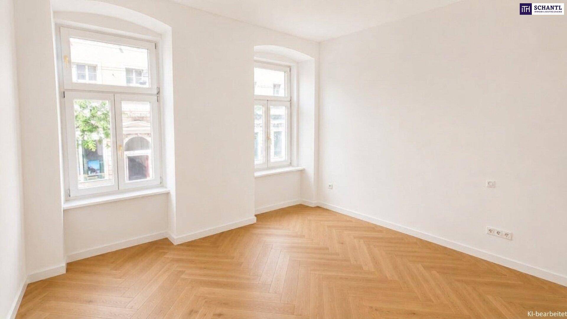 Lichtdurchflutetes Zimmer mit klassischem Fischgrätparkett und zwei Fenstern, die einen Blick nach draußen bieten.