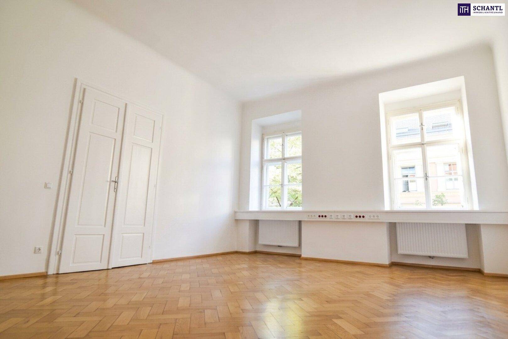 Leerer Raum mit Fischgrätparkett, zwei Fenstern und weißen Wänden, bereit zur Einrichtung.