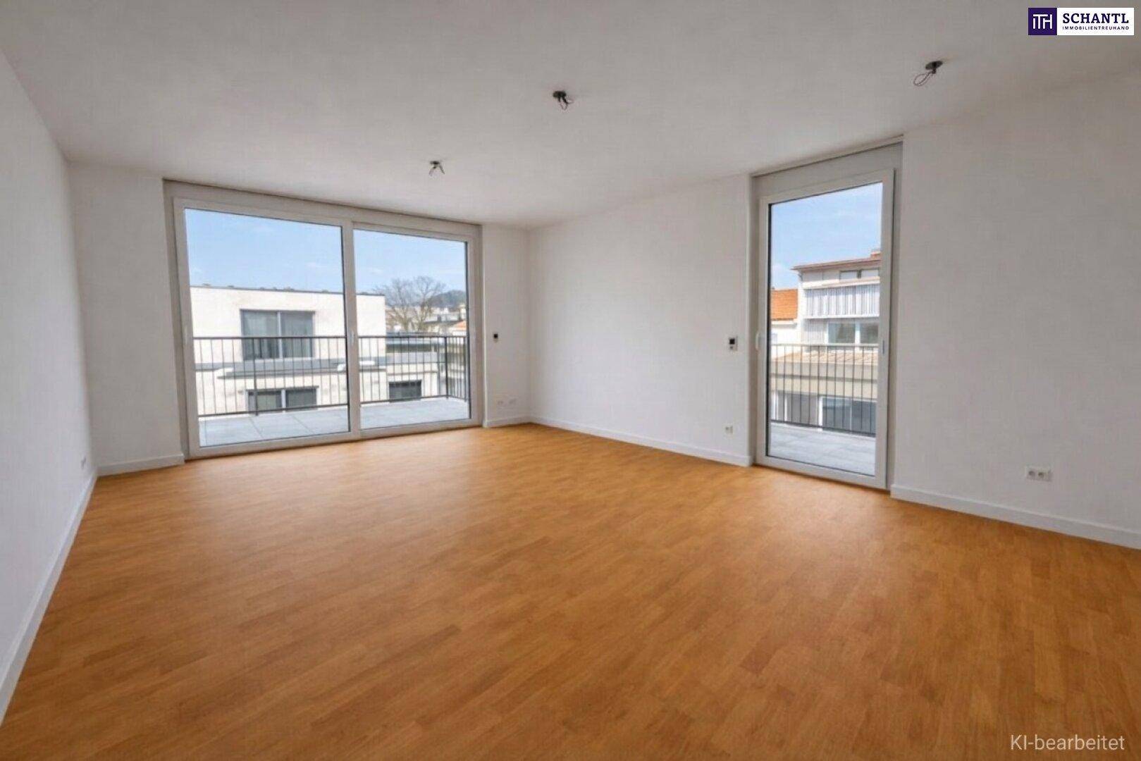 Heller, leerer Wohnraum mit großen Fenstern, Laminatboden und Zugang zu einem Balkon.