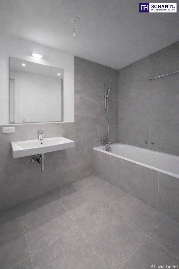 Modernes Badezimmer mit grauen Fliesen, Waschbecken und Badewanne mit Duschfunktion.