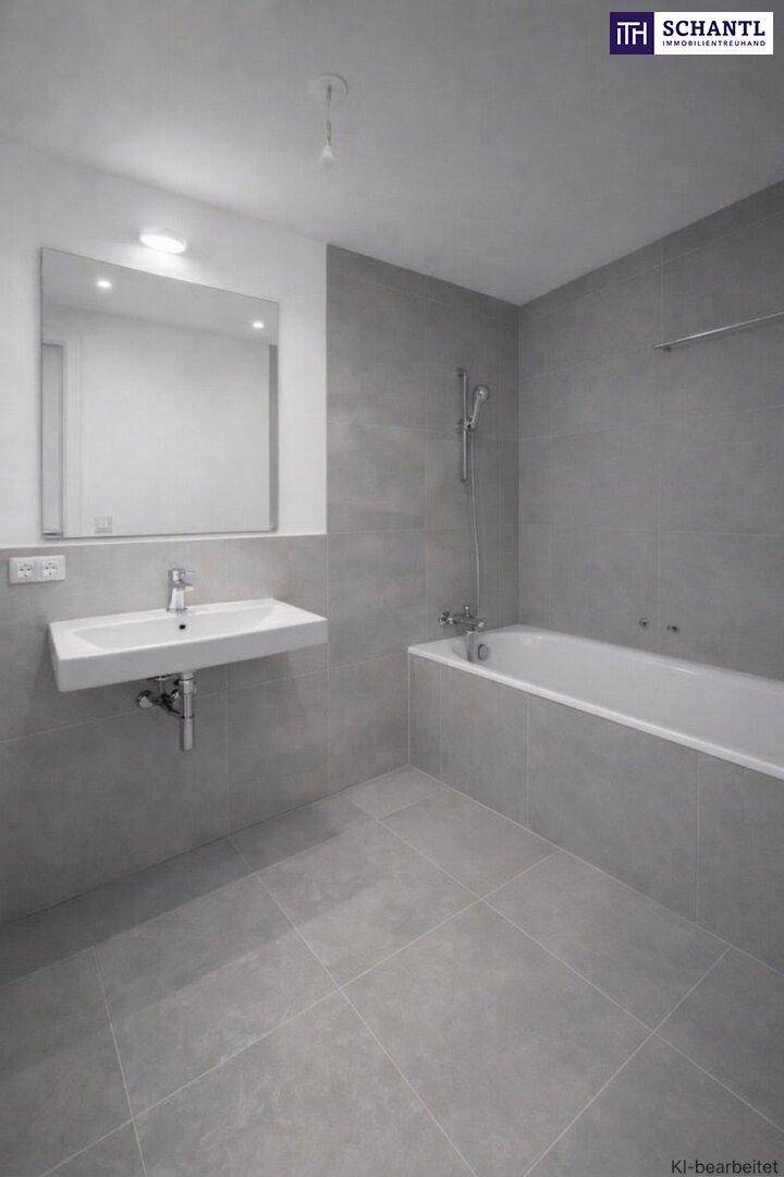 Modernes Badezimmer mit grauen Fliesen, einer Badewanne mit Duschfunktion und einem wandmontierten Waschbecken.