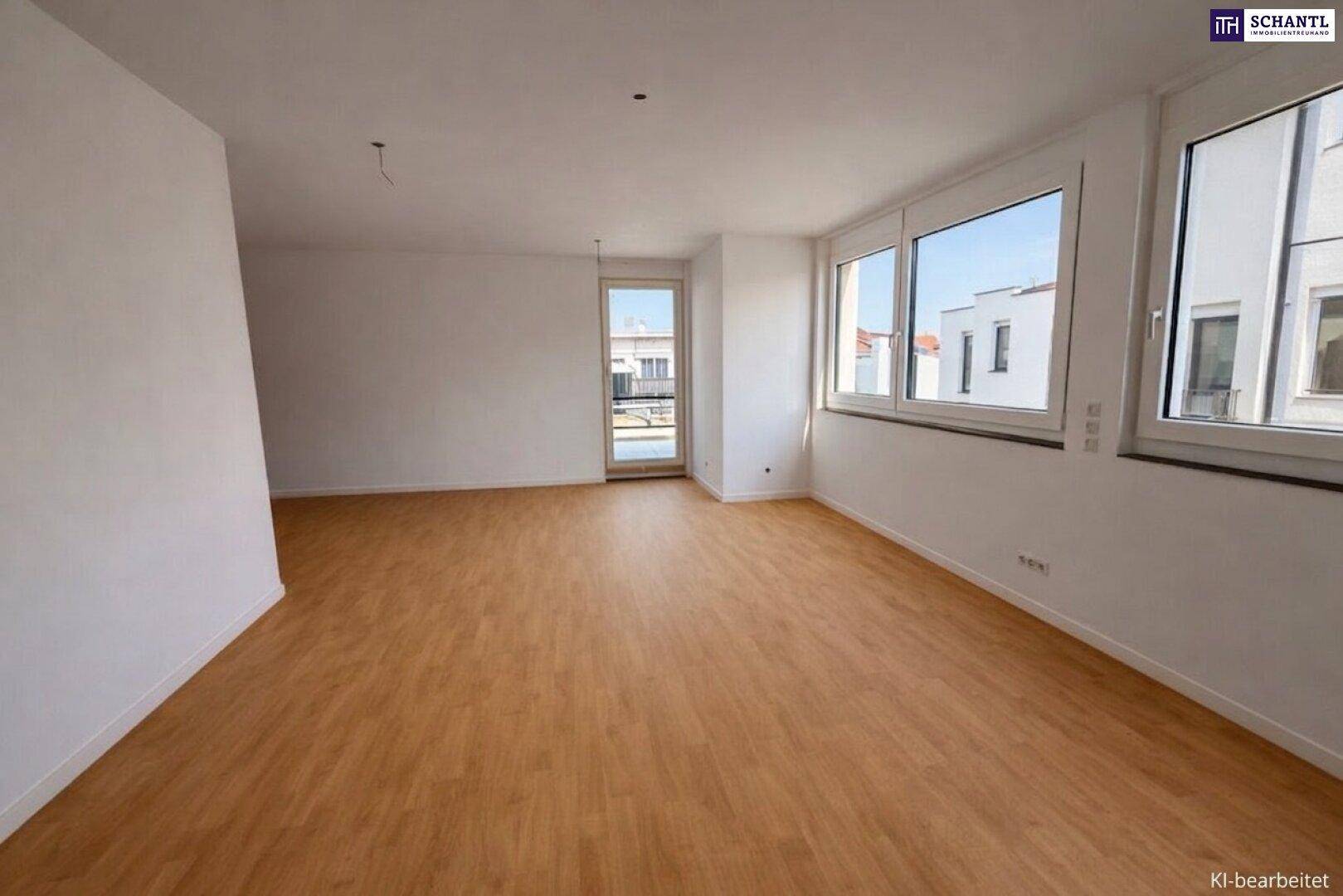 Helles, leeres Wohnzimmer mit großen Fenstern, Laminatboden und Zugang zu einem Balkon.