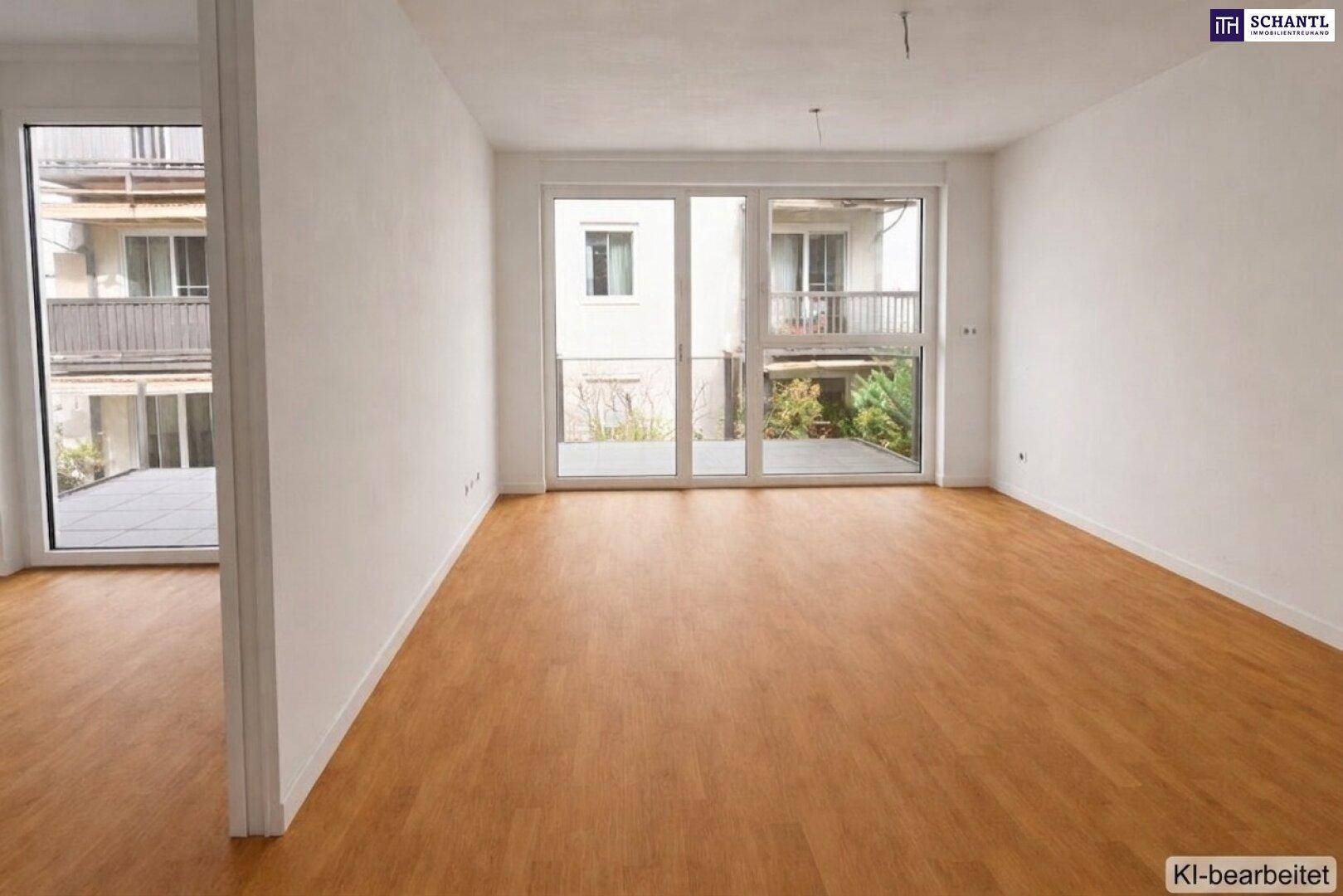 Helles Zimmer mit Holzboden und großen Fenstern, die Zugang zu einem Außenbereich bieten.