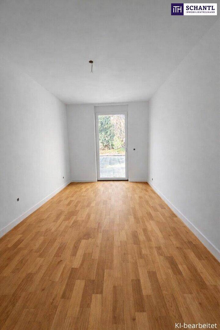 Leeres Zimmer mit hellem Holzboden und einer Glastür, die ins Freie führt.