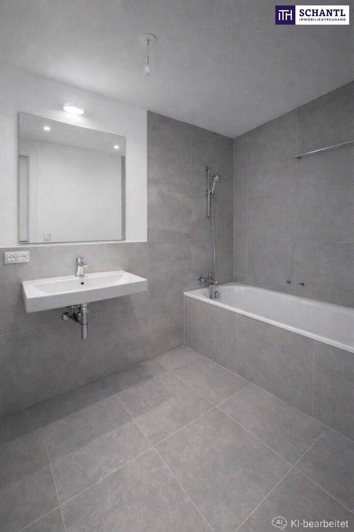 Modernes Badezimmer mit grauen Fliesen, wandhängendem Waschbecken und einer Badewanne mit Duschfunktion.