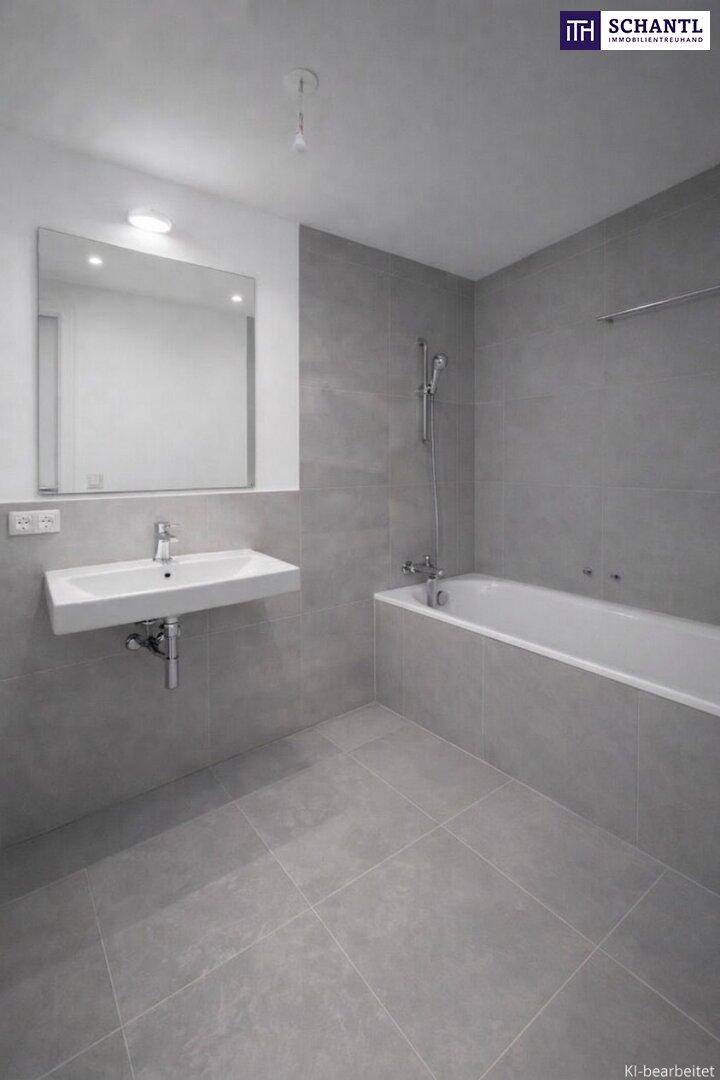 Modernes Badezimmer mit grauen Fliesen, Badewanne und wandhängendem Waschbecken.