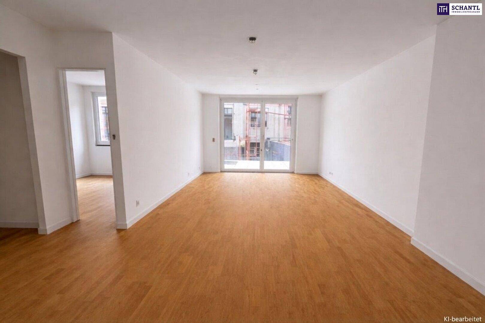Leeres Wohnzimmer mit Holzboden und großen Fenstern, die viel Tageslicht hereinlassen.