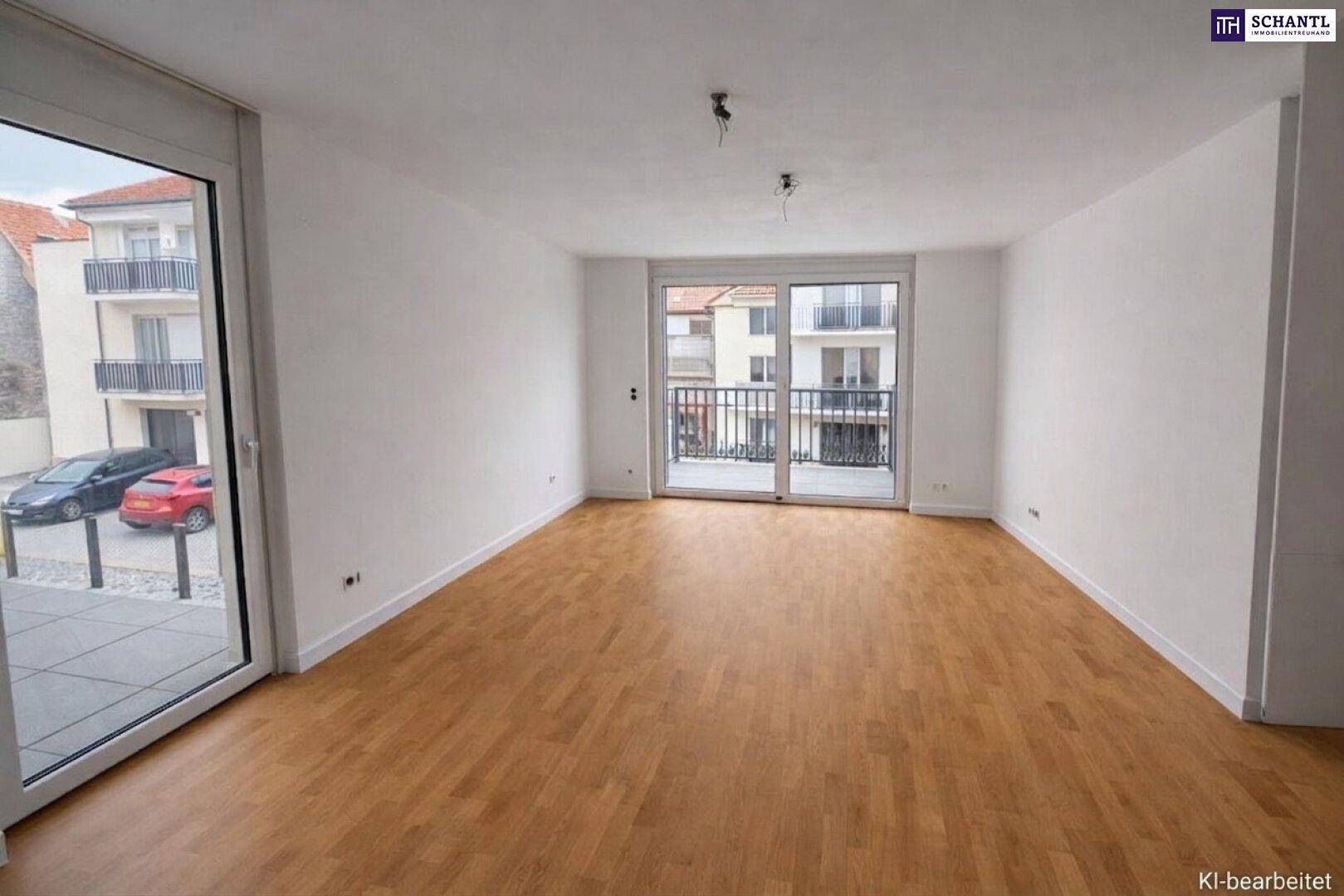 Helles, leeres Wohnzimmer mit Holzboden und Zugang zu einem Balkon mit Blick auf die Straße.