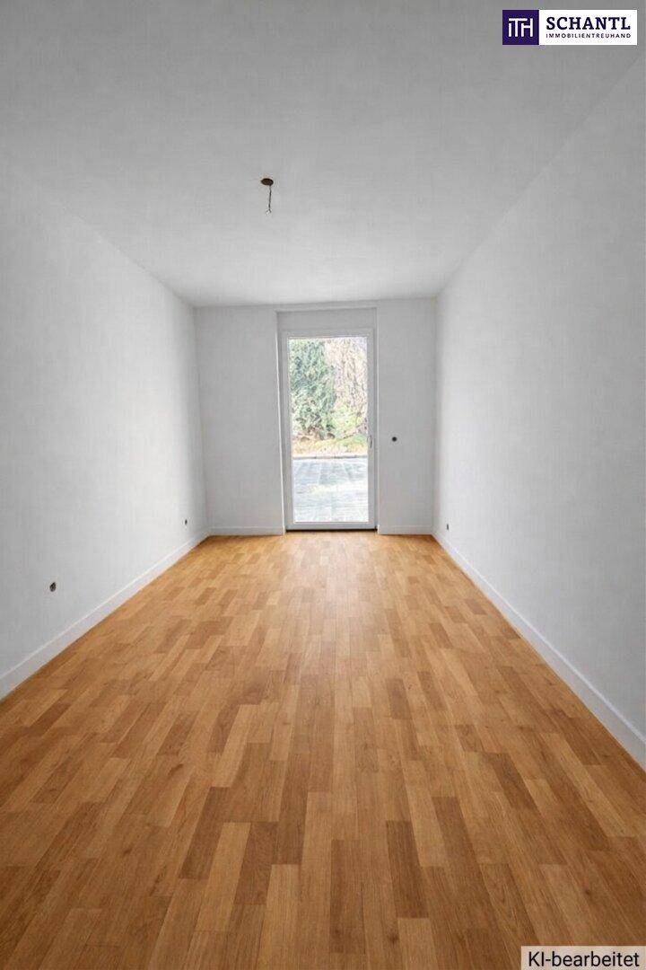 Heller, leerer Raum mit Holzboden und Zugang zu einem Außenbereich.