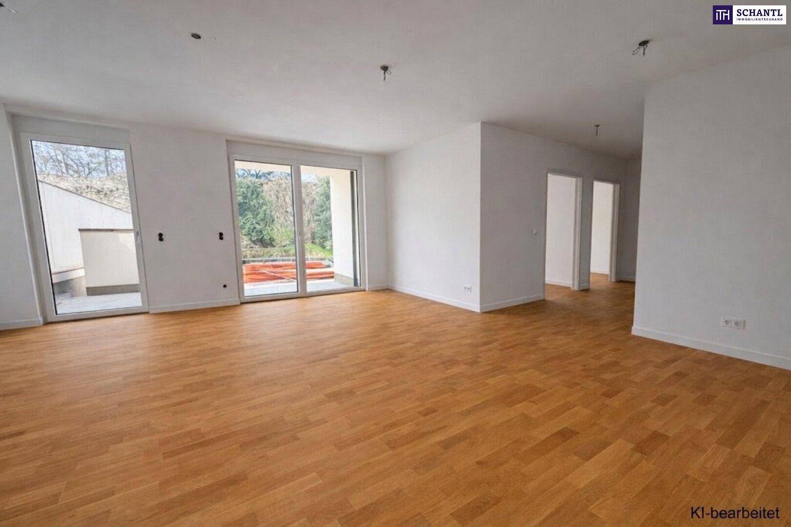 Geräumiger, heller Wohnbereich mit Holzboden und großen Fenstern zum Außenbereich.